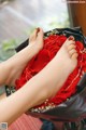 A woman's feet in a box of red roses.