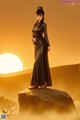 A woman in a long dress standing on a rock.