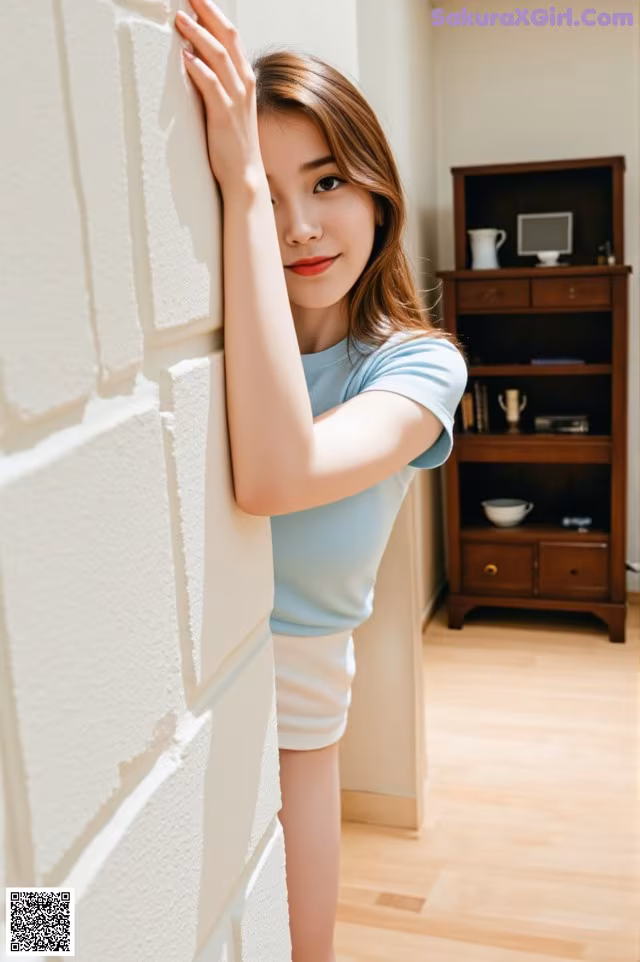 A woman leaning against a wall with her hand on the wall.