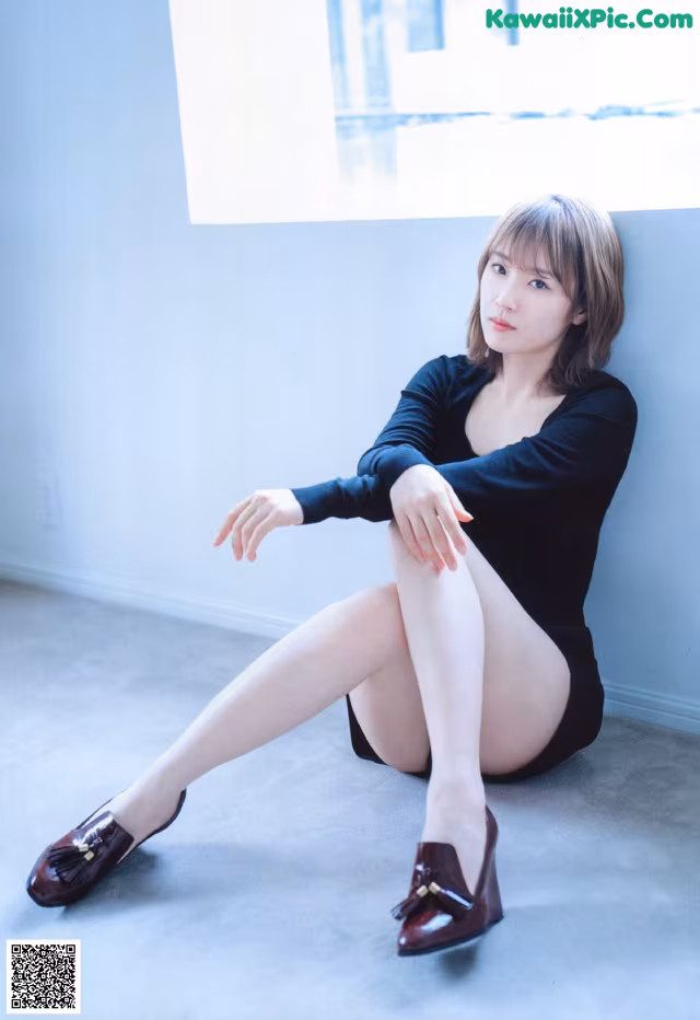 A woman sitting on the floor with her legs crossed.