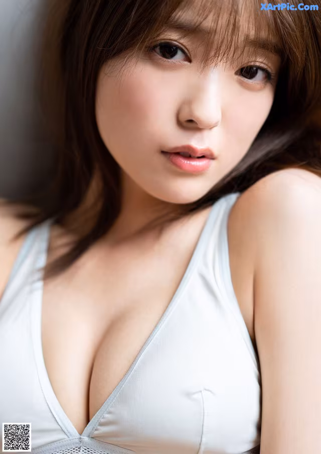 A woman in a white bra top posing for a picture.