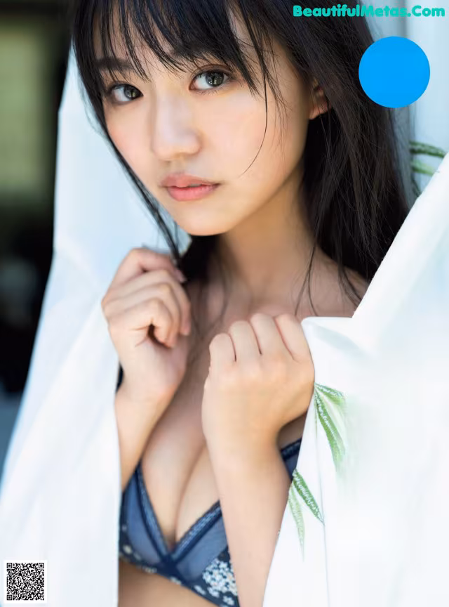 A woman in a blue bra top is posing for a magazine cover.